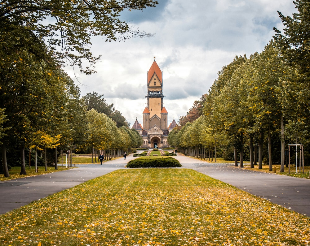 a large clock tower towering over a lush green park