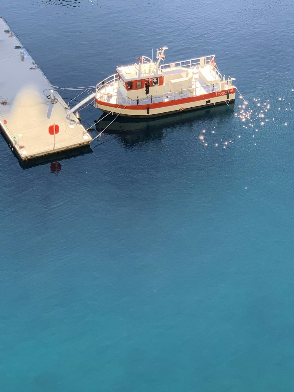 a boat docked at a pier in the ocean