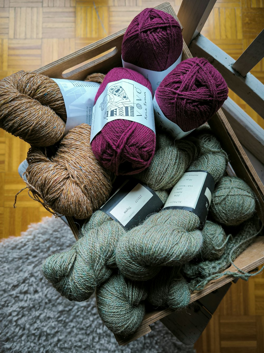 a wooden crate filled with balls of yarn