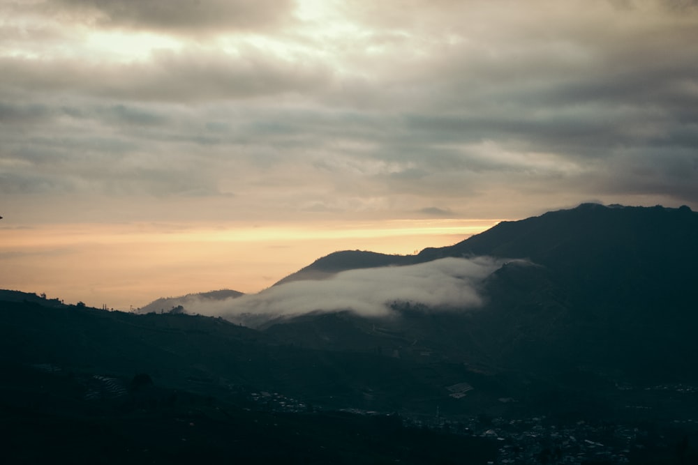 a view of a mountain range with low lying clouds