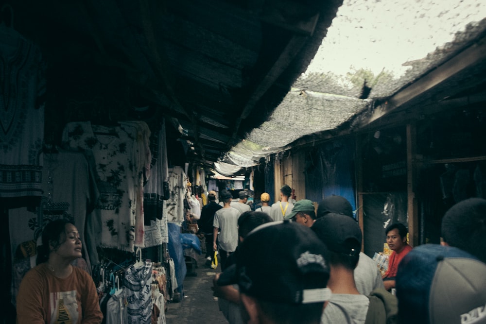 a group of people walking down a street next to shops