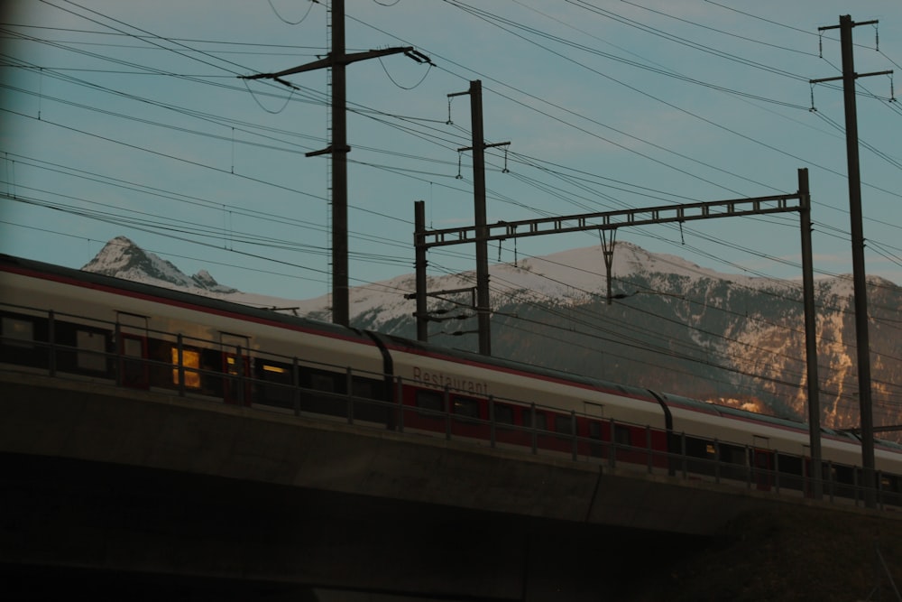 a train traveling over a bridge with mountains in the background