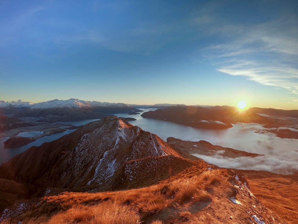 the sun is setting over a mountain range