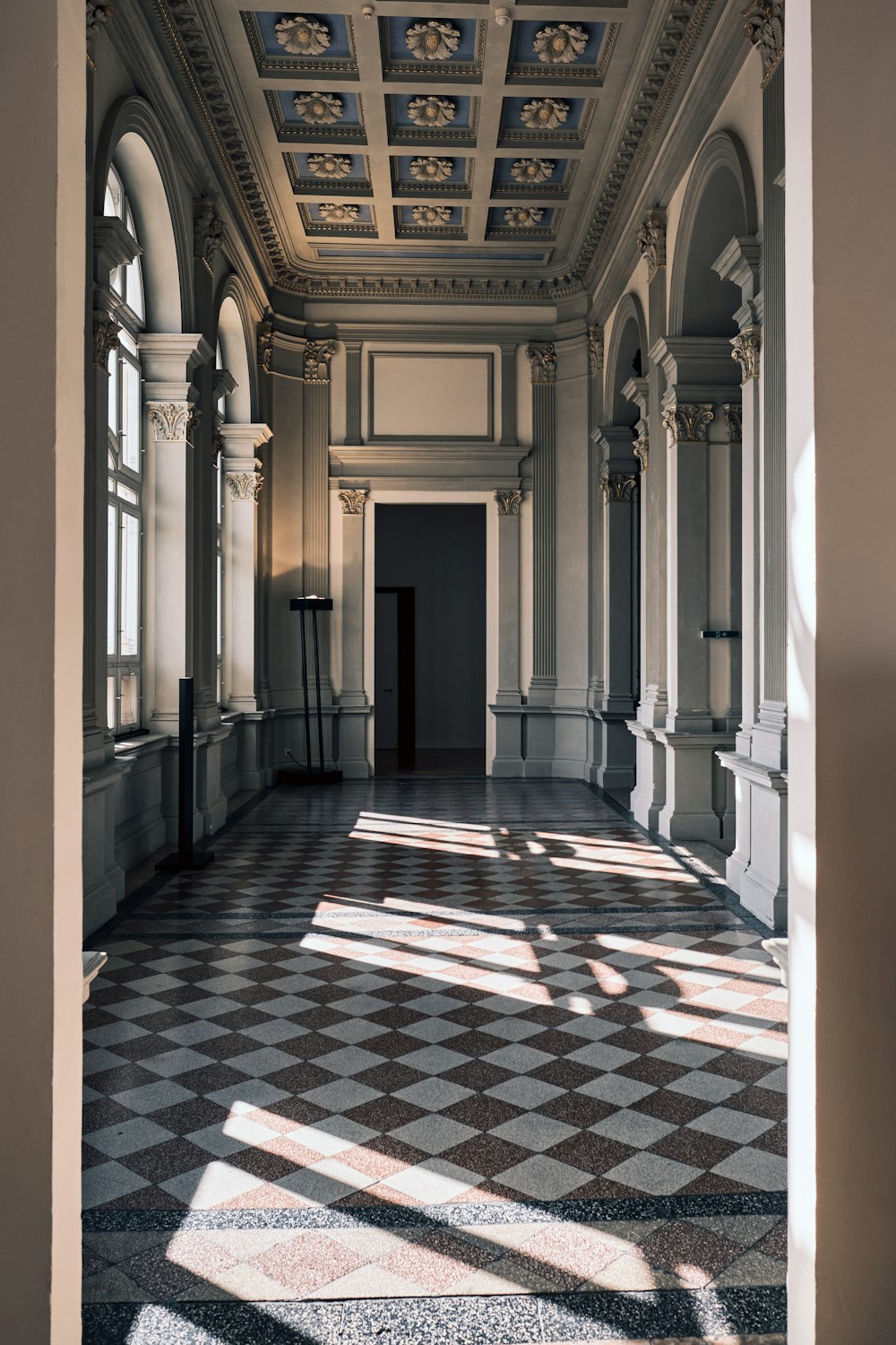 a hallway with a checkered floor and a ceiling