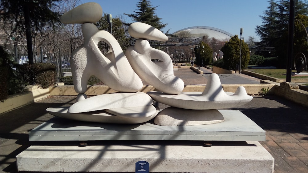 a sculpture of a bird on a rock in the middle of a park