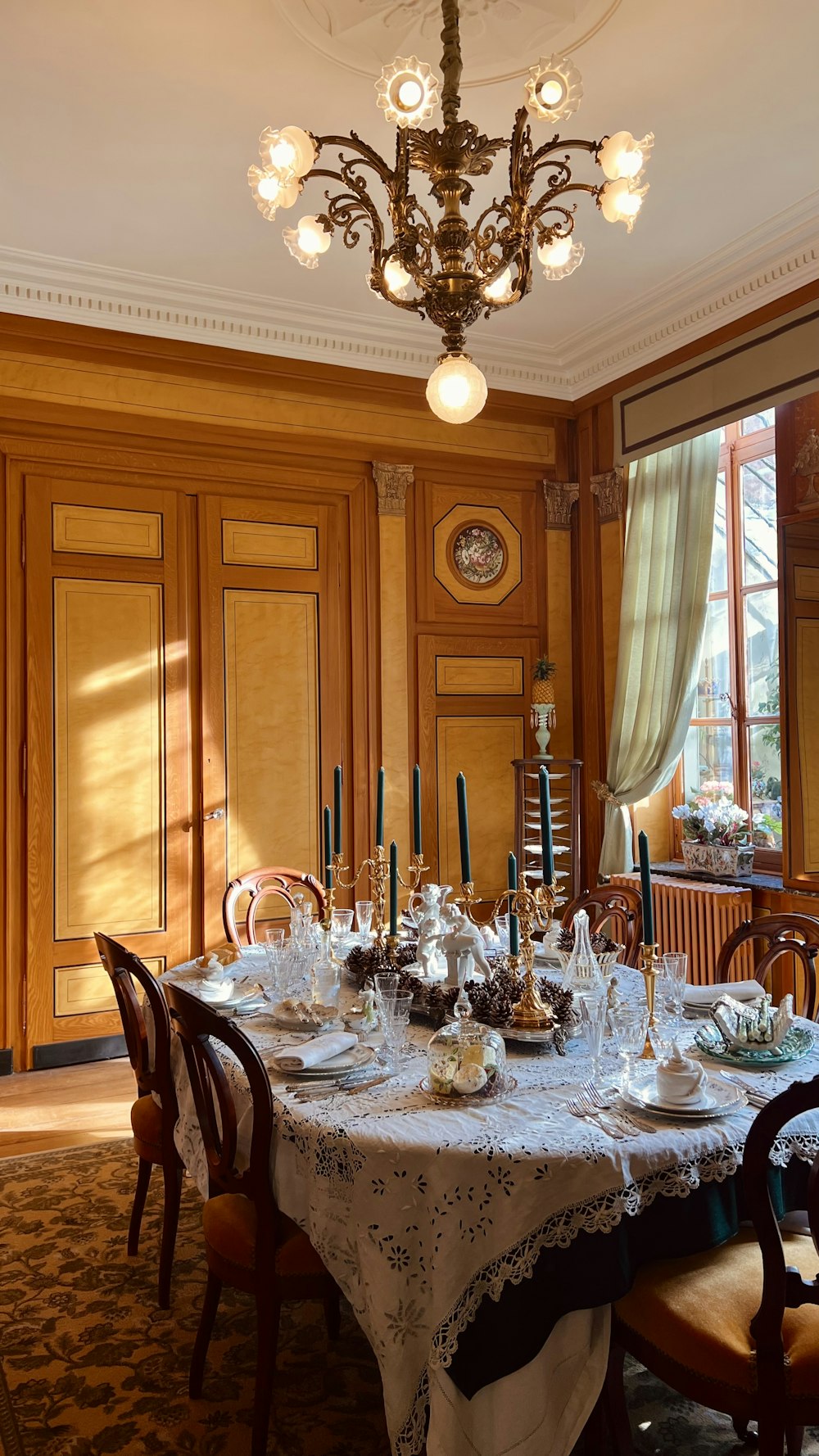 a dining room table with a fancy chandelier