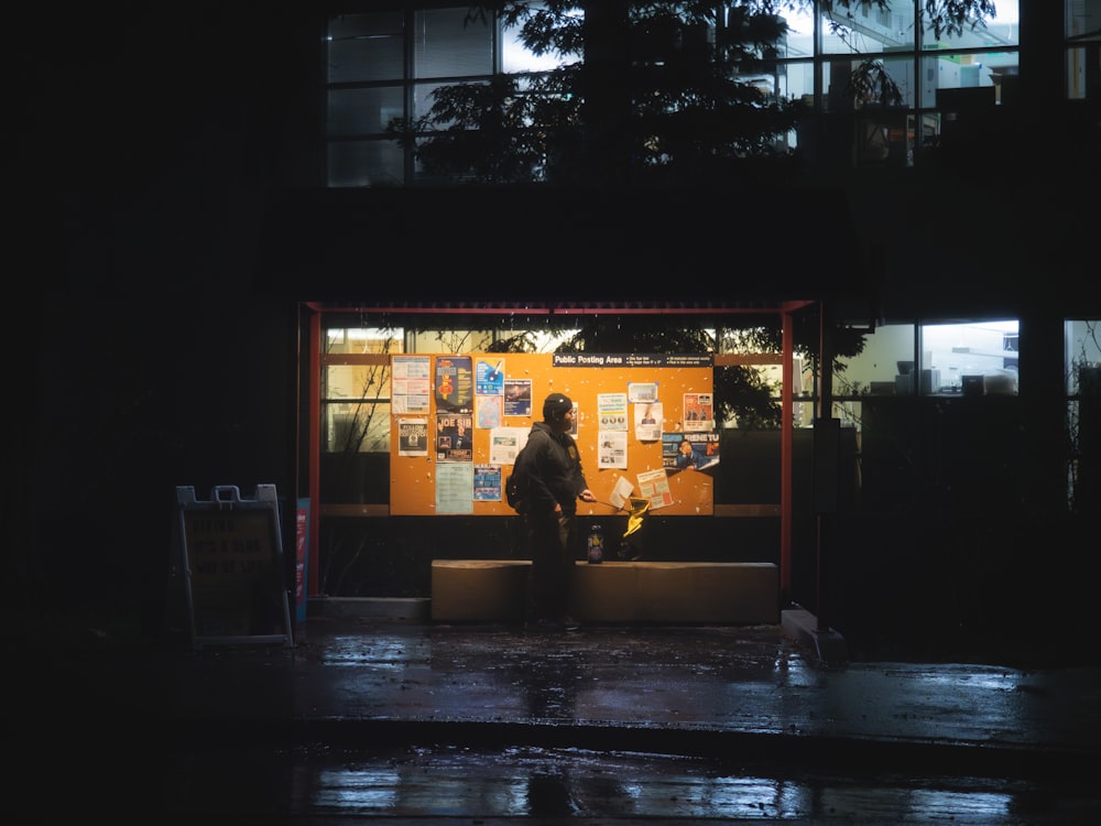 a person sitting on a bench in front of a building