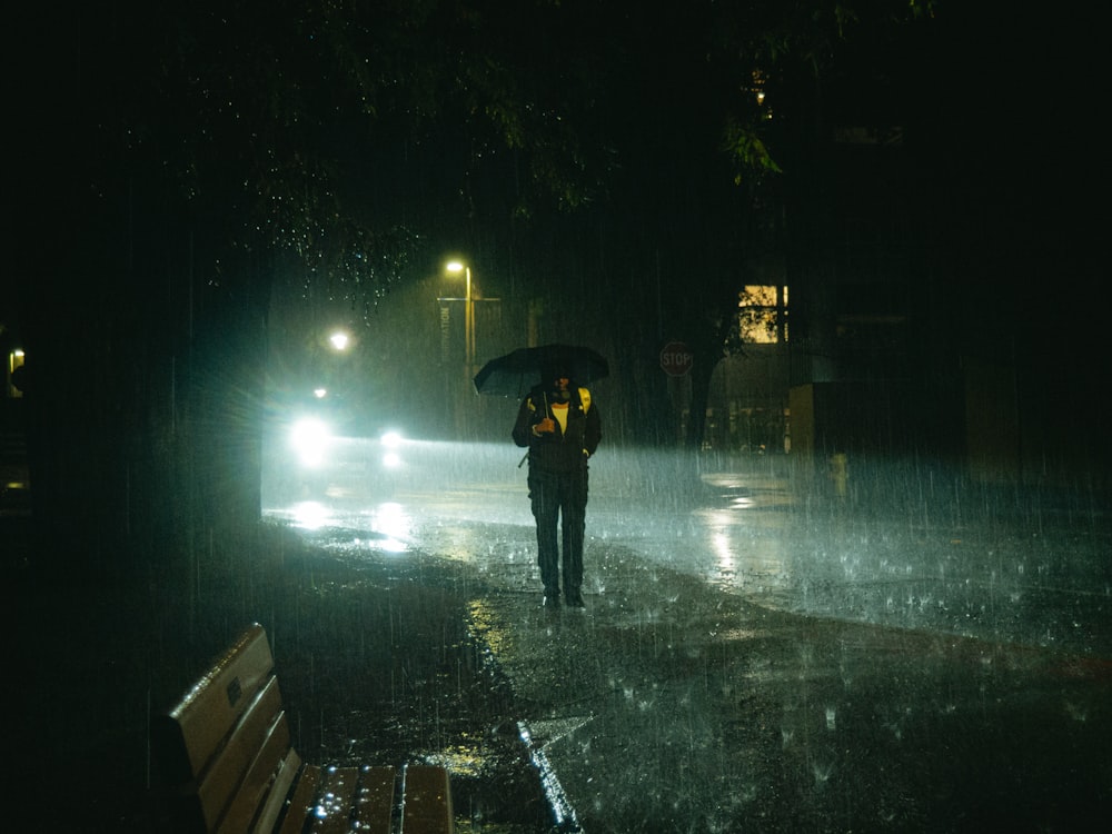 una persona caminando bajo la lluvia con un paraguas