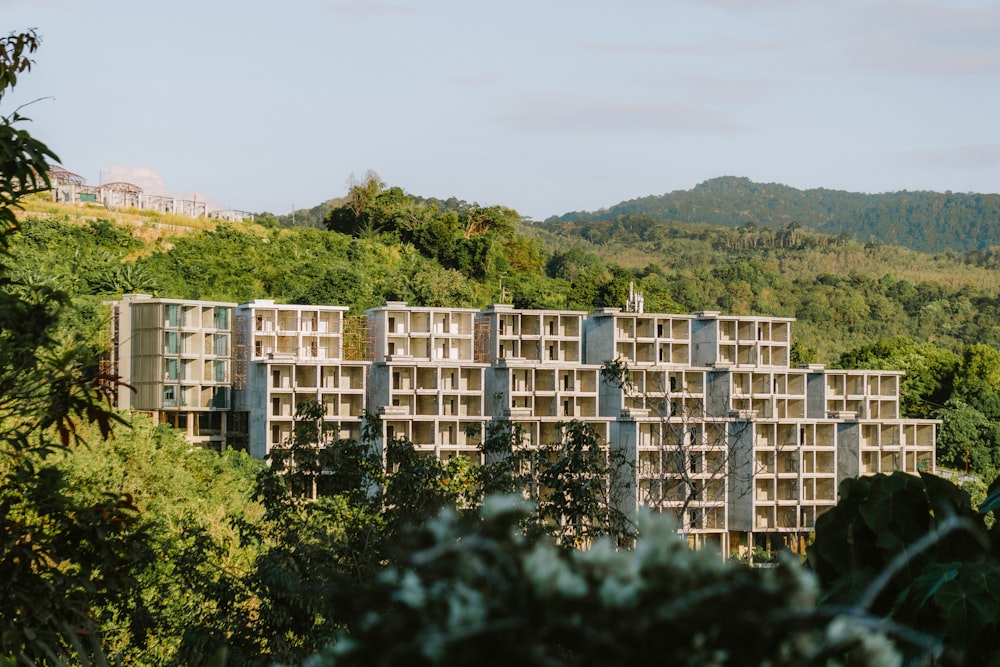 a tall building sitting on top of a lush green hillside