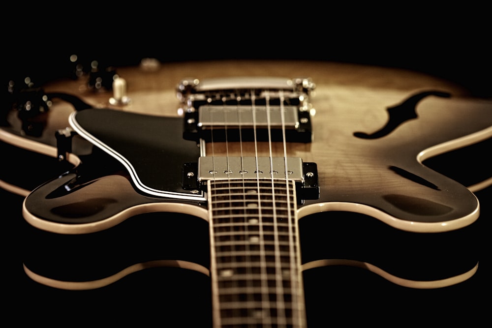 a close up of a guitar with a black background