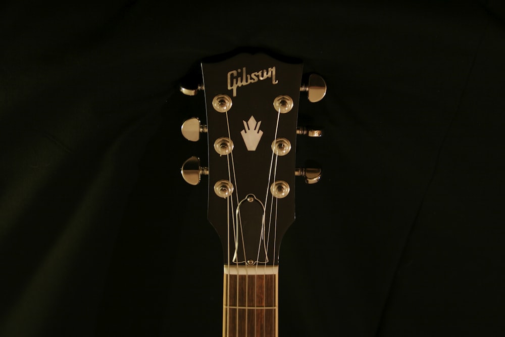 a close up of a guitar with a black background