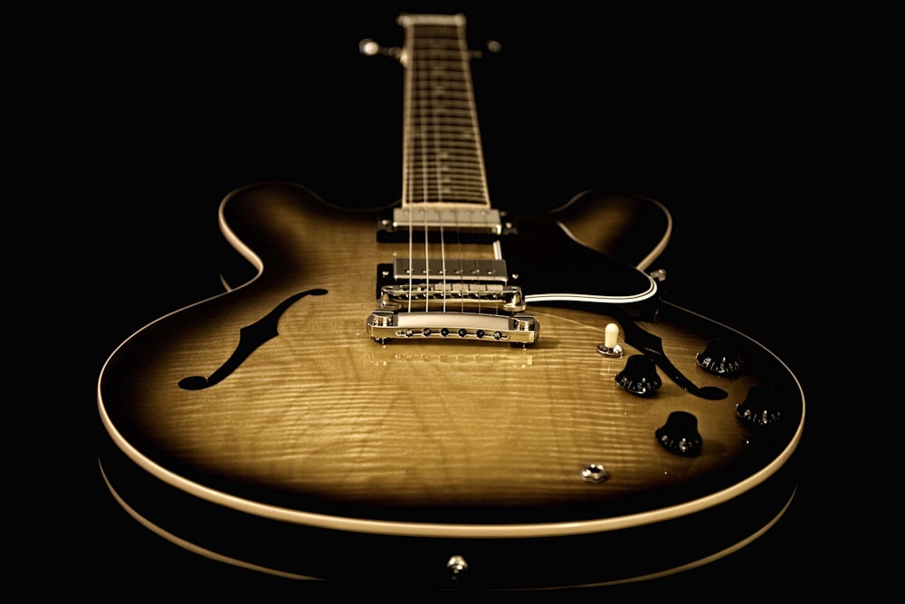 a close up of a guitar on a black background