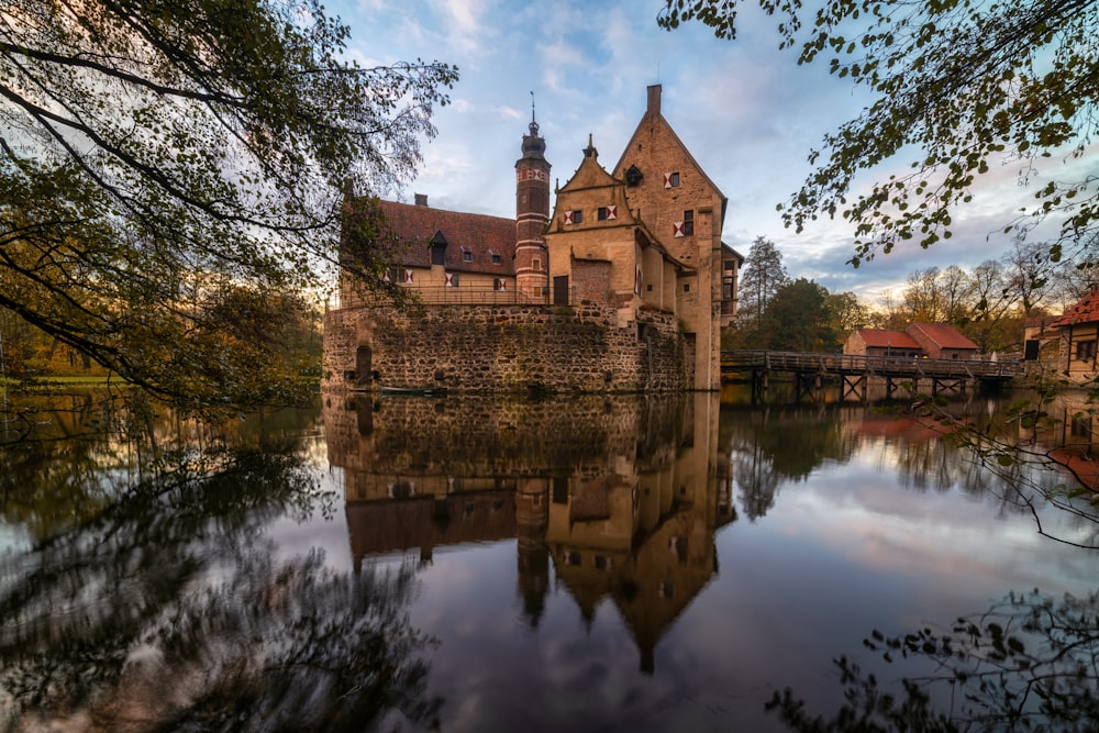 a castle is reflected in the still water of a river