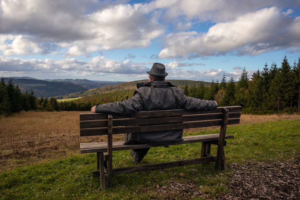 a man sitting on a bench in a field