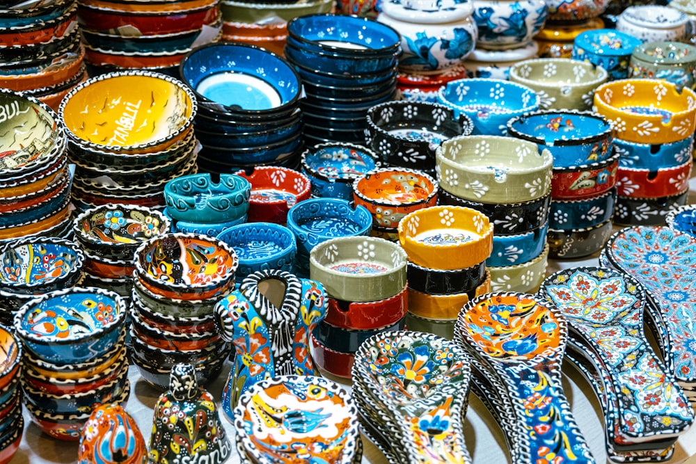 a table topped with lots of colorful plates and bowls