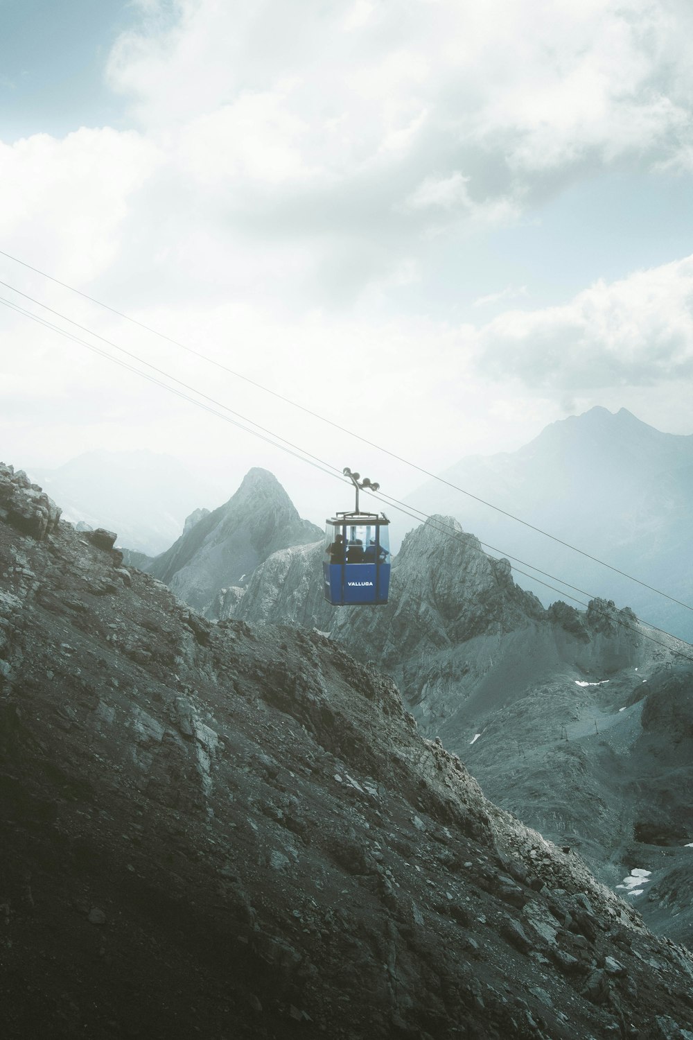 a ski lift going up a mountain on a cloudy day