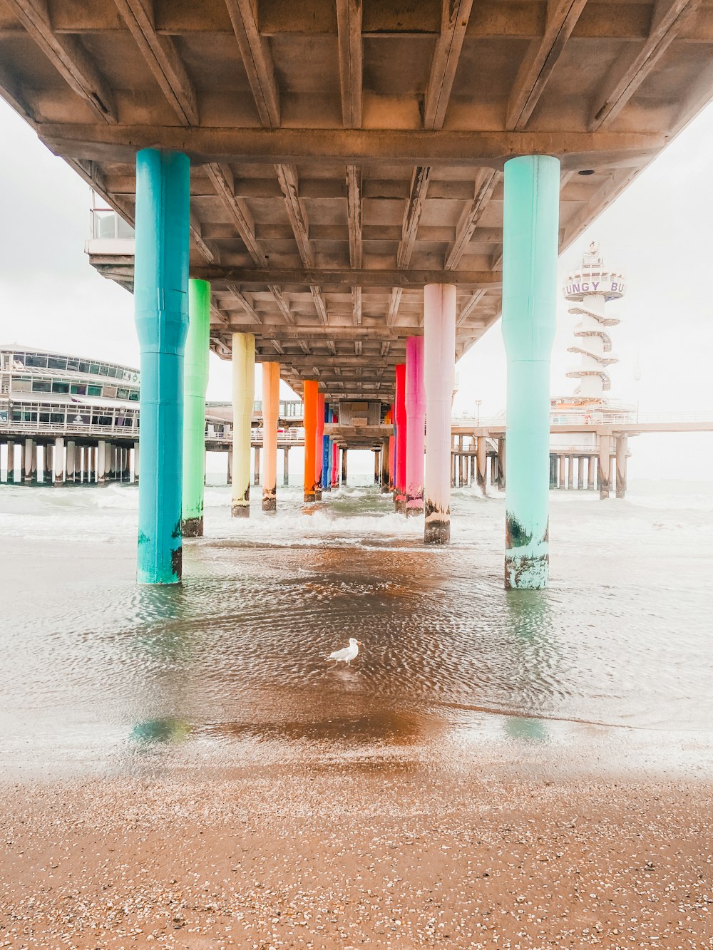 the underside of a bridge with colorful columns