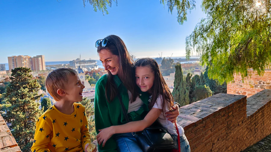 A parent and two children sitting together outdoors on a trip