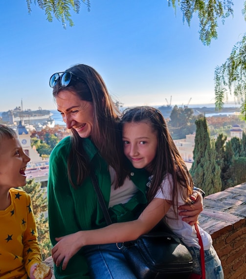 a woman and two children sitting on a bench