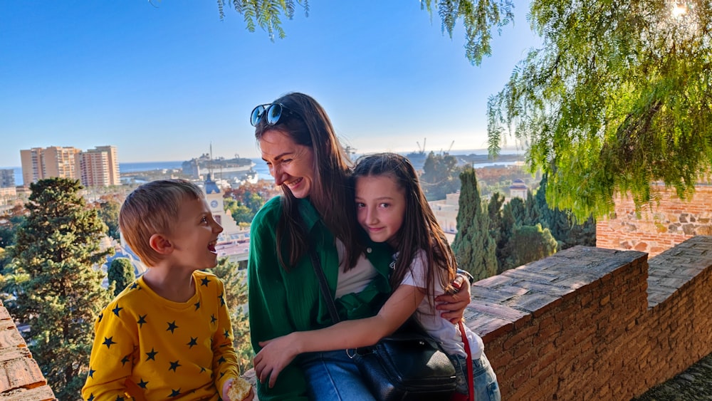 a woman and two children sitting on a bench