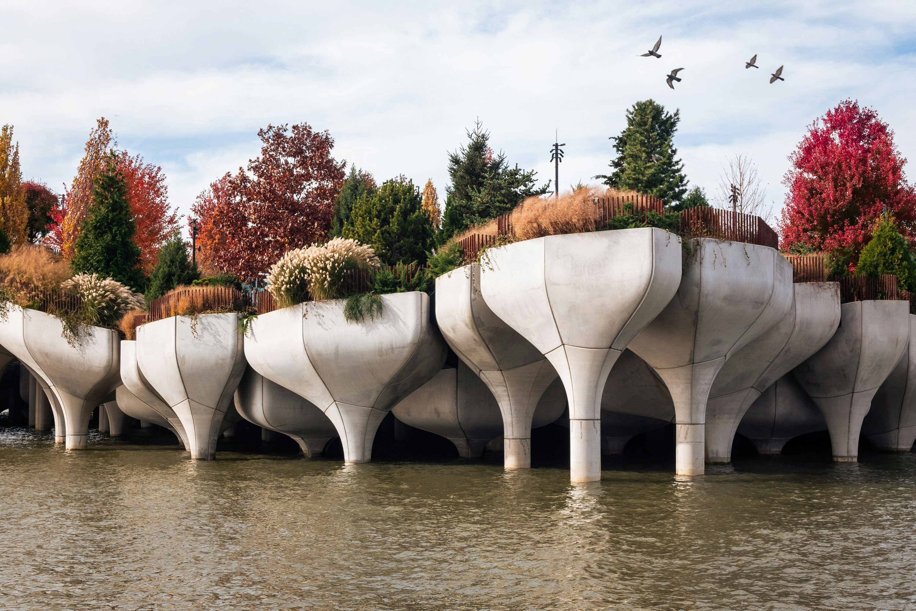 a row of concrete planters sitting on top of a river