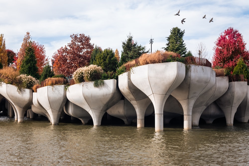 uma fileira de plantadores de concreto sentados no topo de um rio