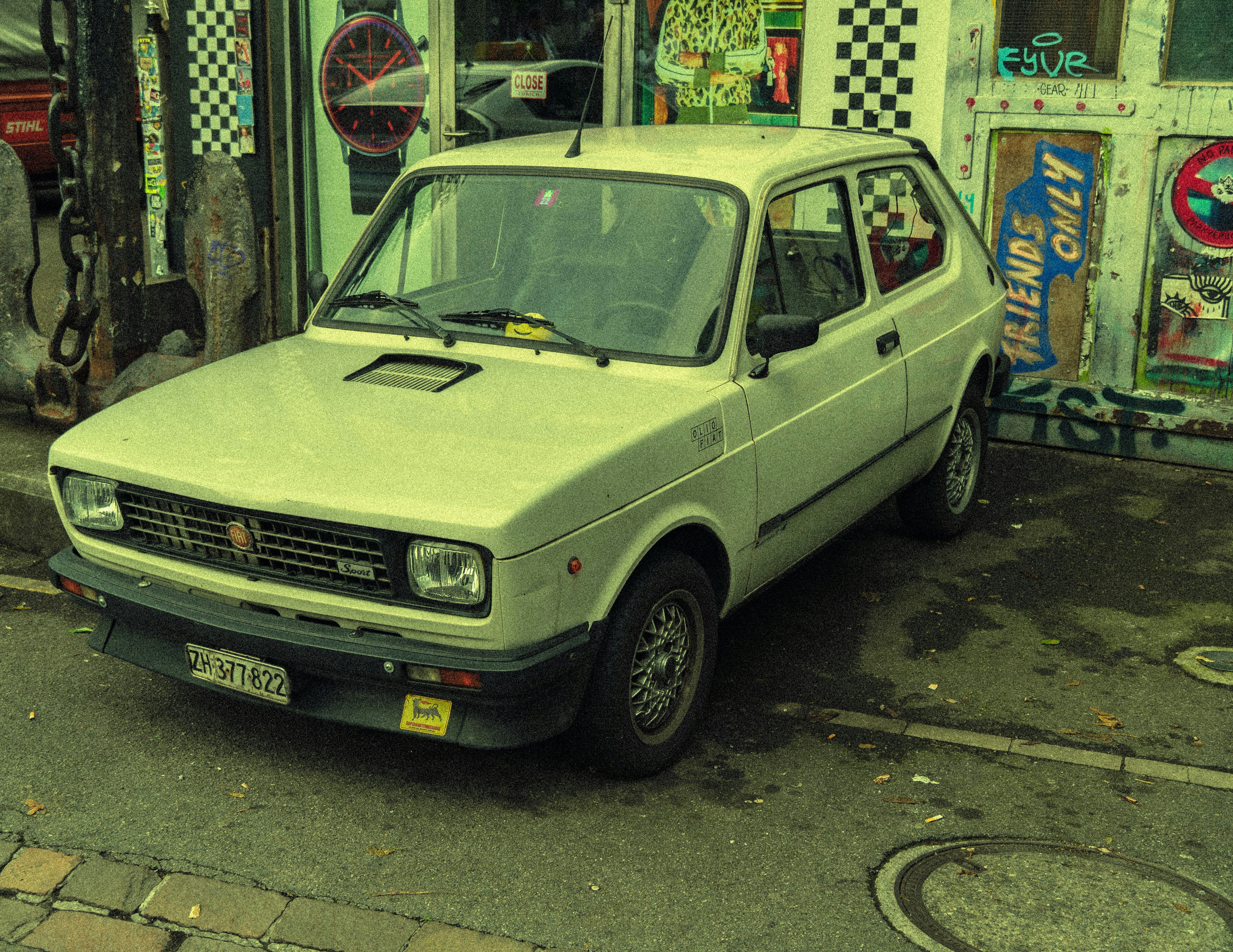 um pequeno carro estacionado em frente a uma loja