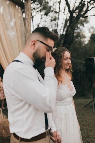 a man standing next to a woman in a white dress