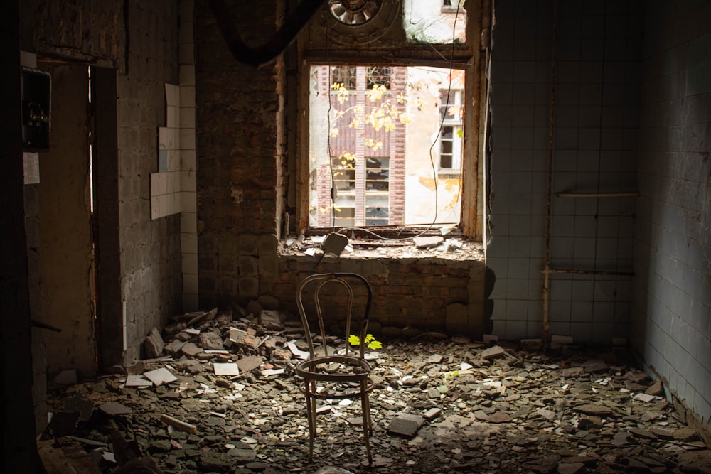 a chair in a run down room with a broken window