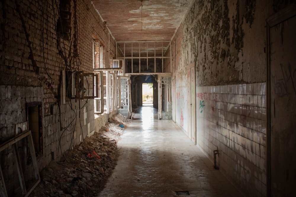 a hallway in an abandoned building with graffiti on the walls