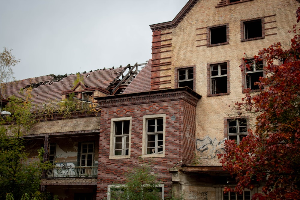 an old brick building with broken windows and graffiti on it