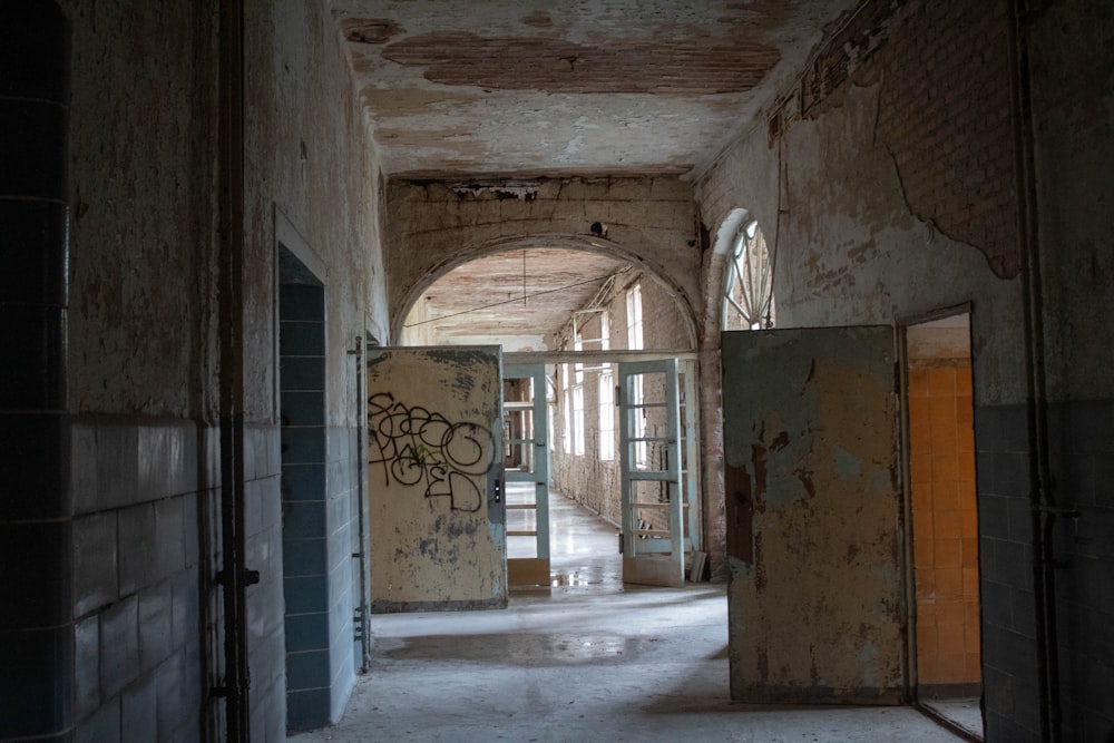 Un pasillo en un edificio abandonado con grafitis en las paredes