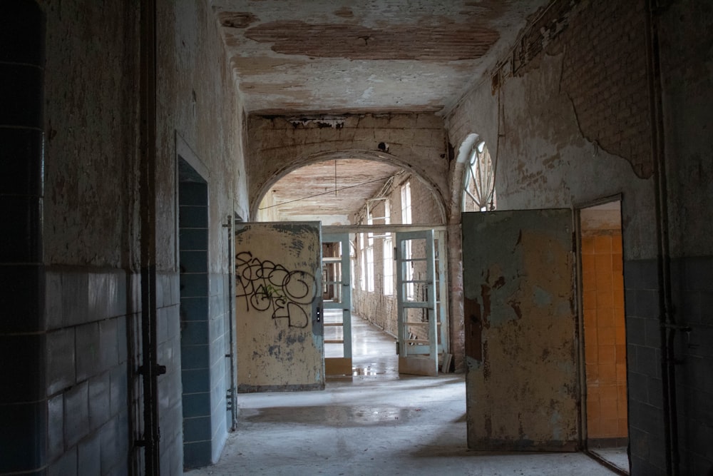 a hallway in an abandoned building with graffiti on the walls