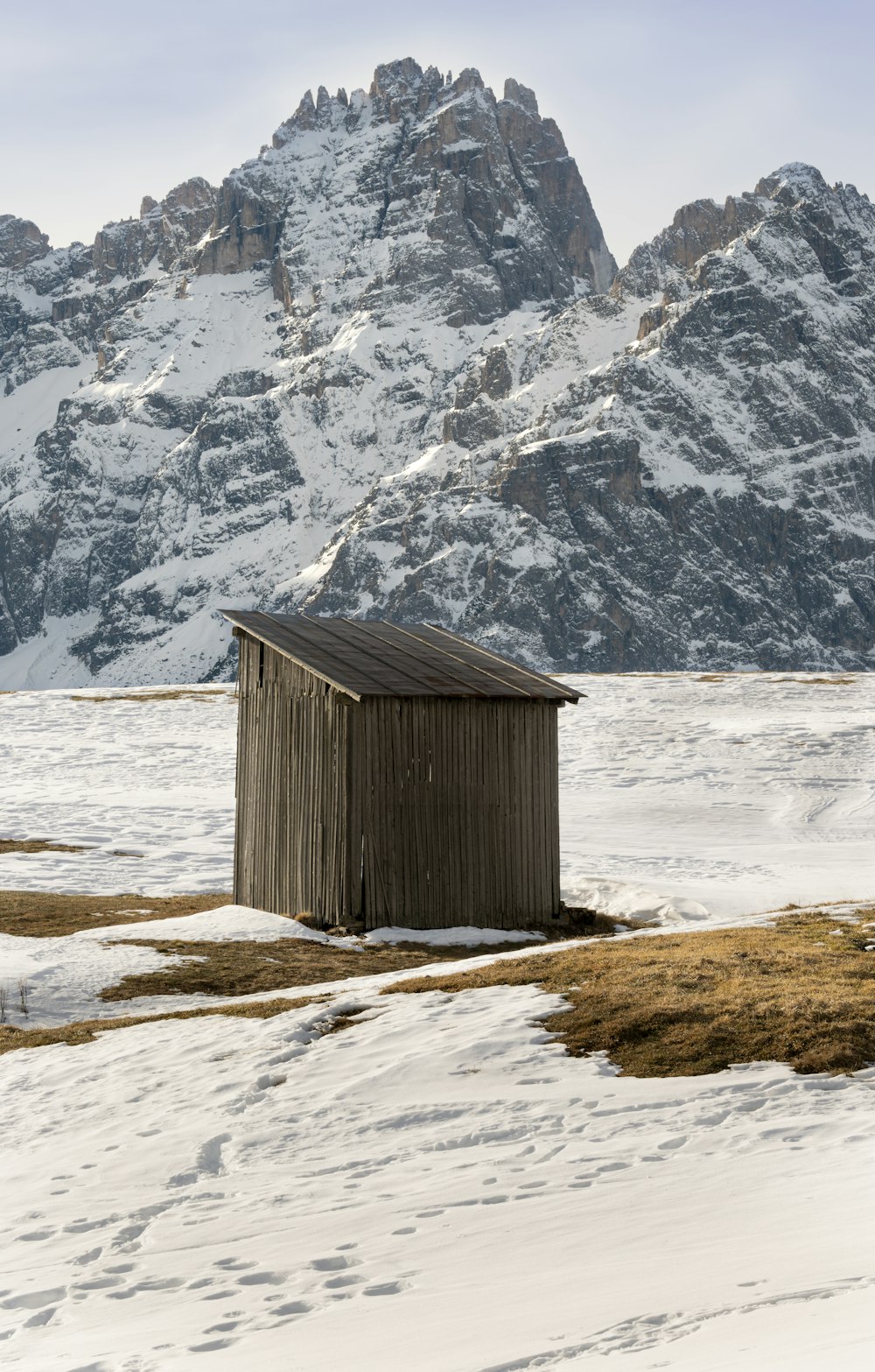 an outhouse in the middle of a snowy field