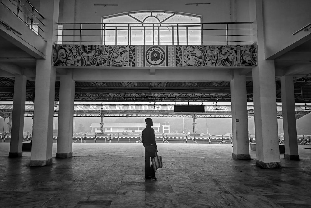 a person standing in a large building with a luggage bag