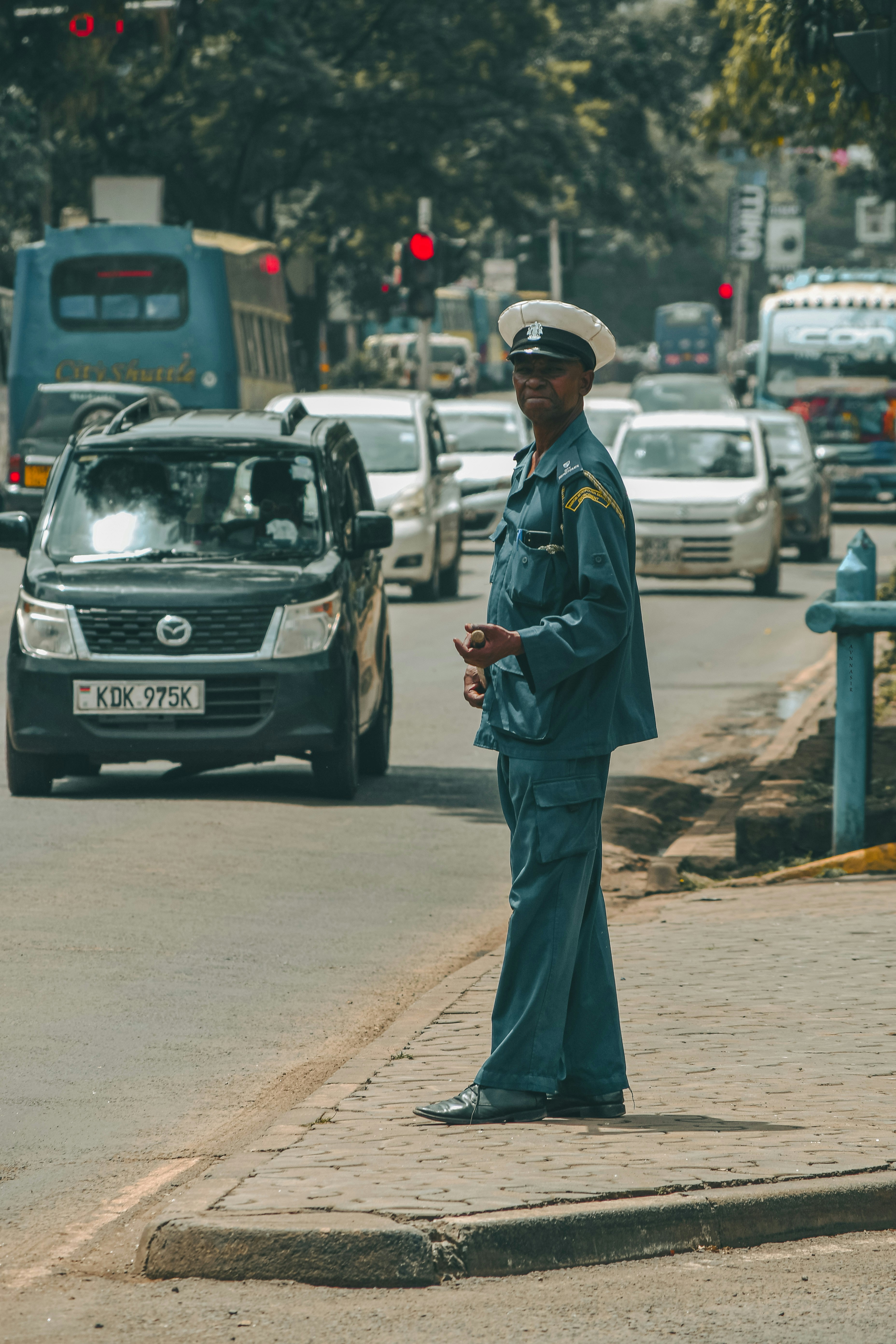 un homme en uniforme debout sur le bord d’une route