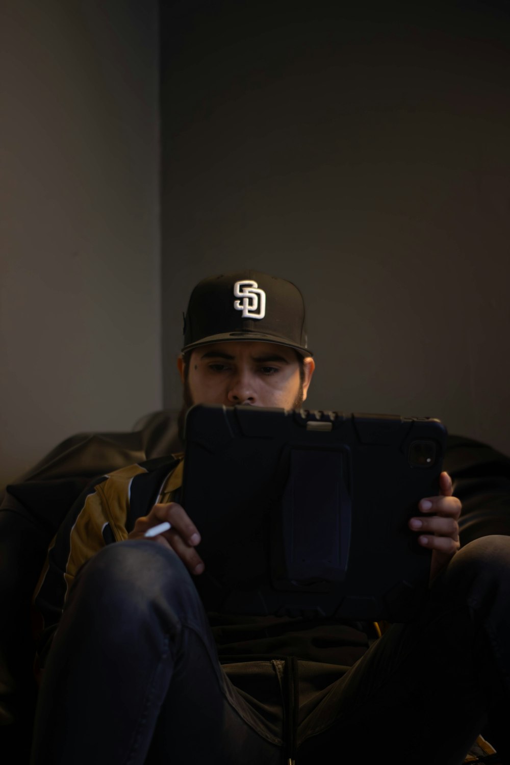 a man sitting on a chair holding a tablet