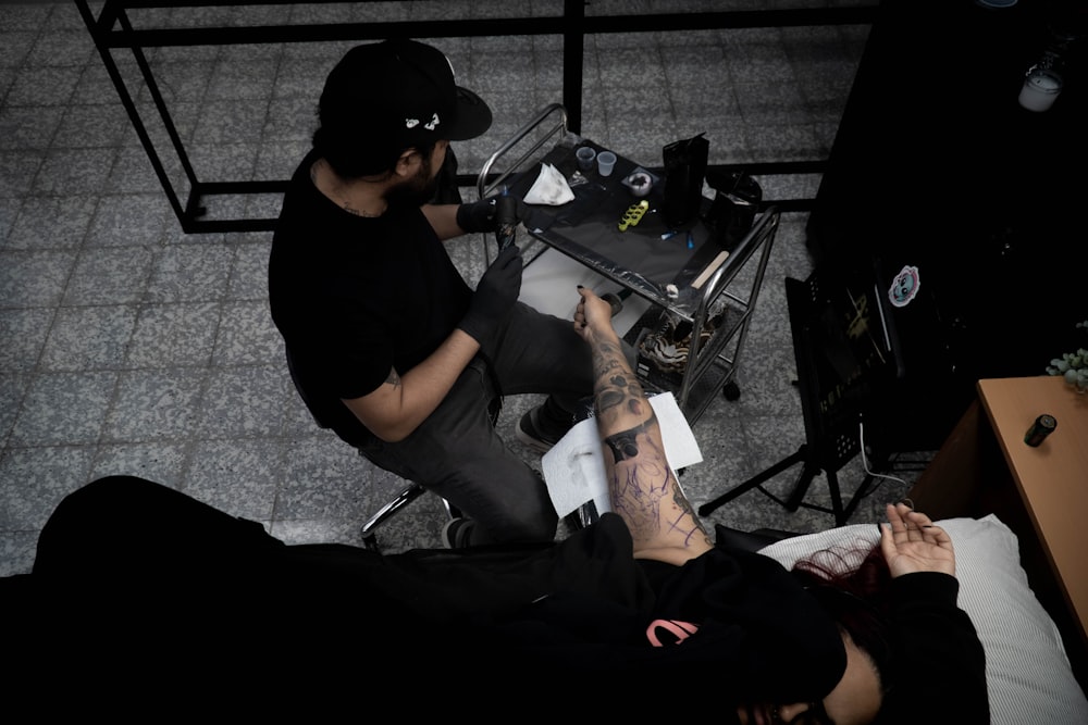 a man with a tattoo sitting next to another man