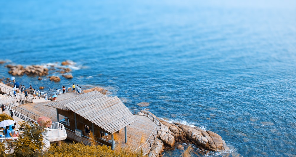 a group of people standing on top of a wooden pier