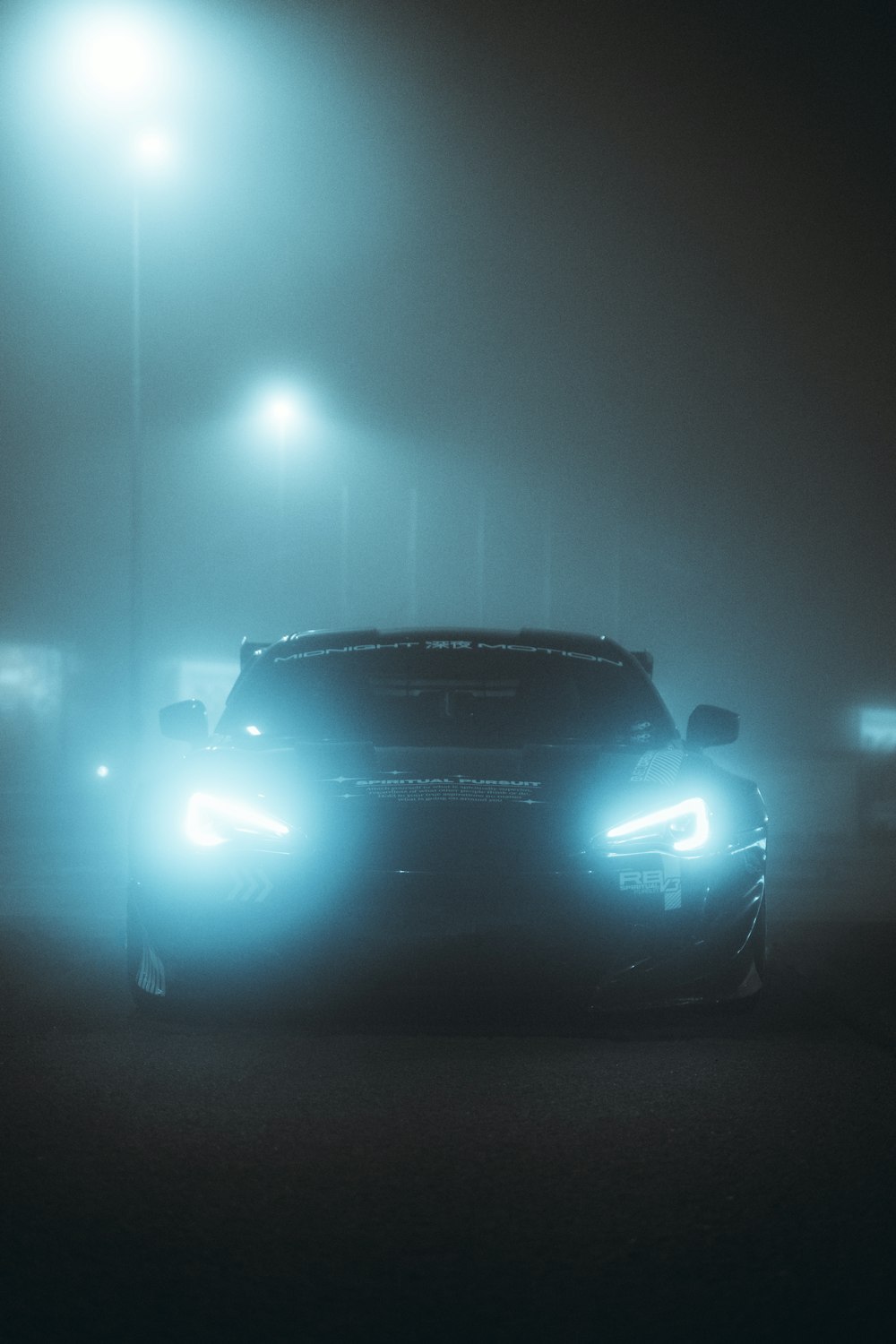 a car driving down a foggy street at night