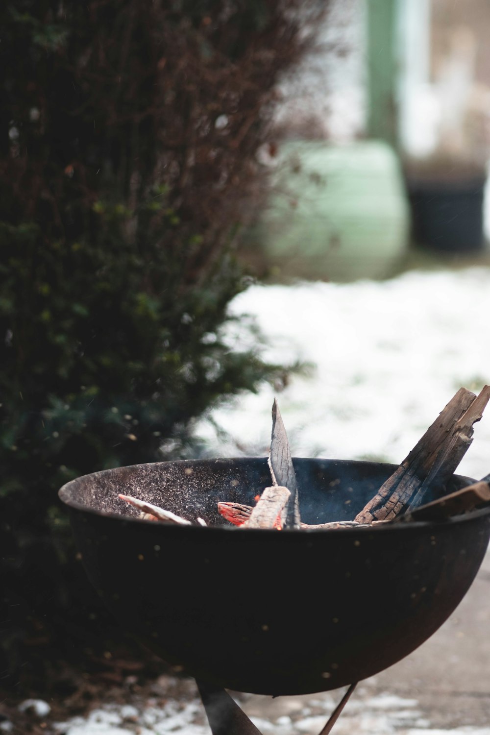 a black fire pit sitting on top of a sidewalk