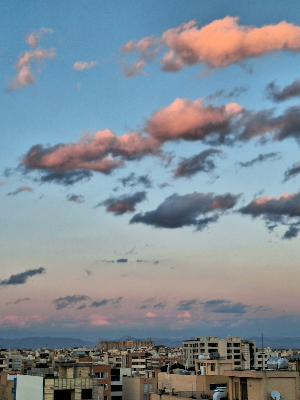 a view of a city from a rooftop at dusk