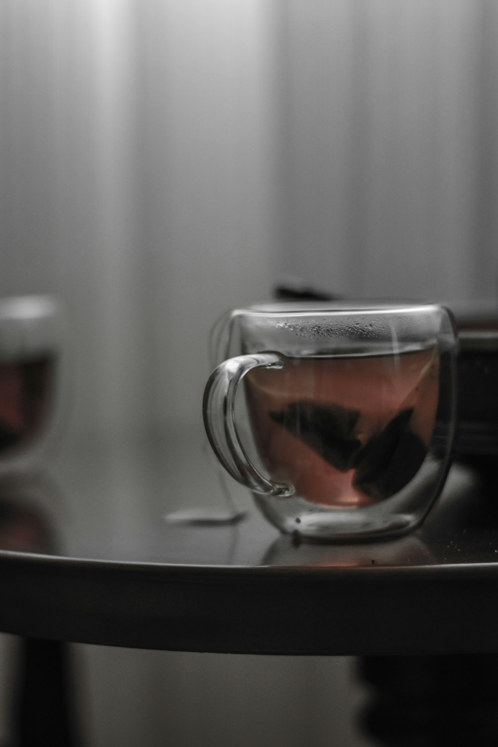 a glass cup with a liquid inside sitting on a table