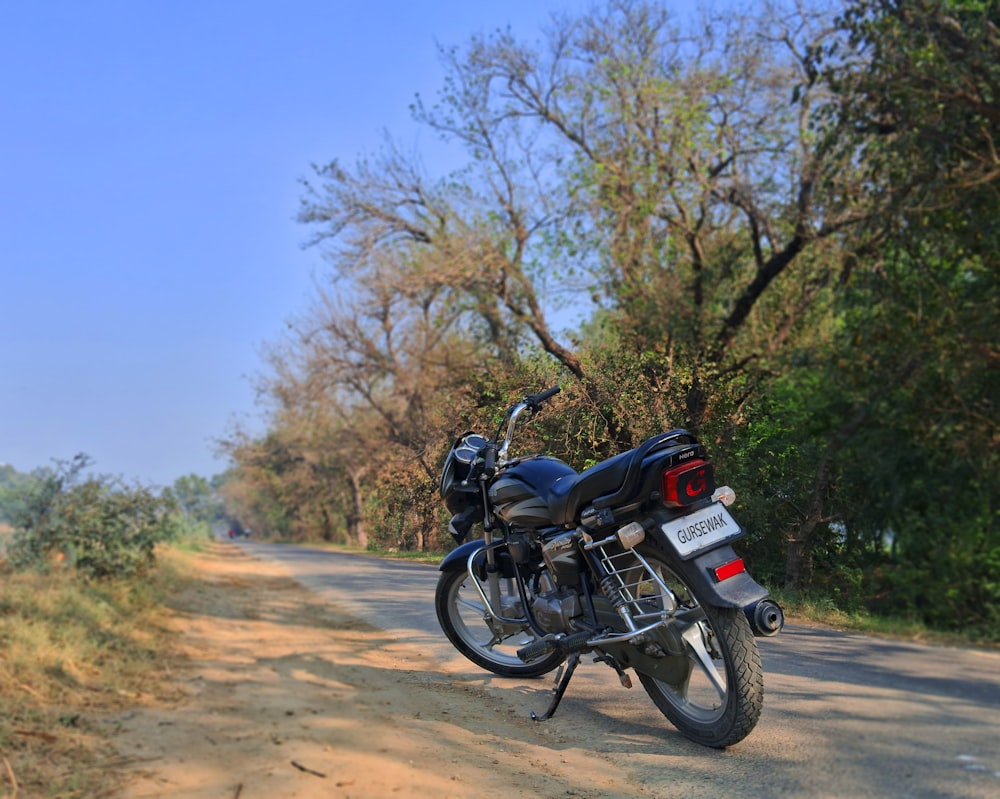 a motorcycle parked on the side of a dirt road