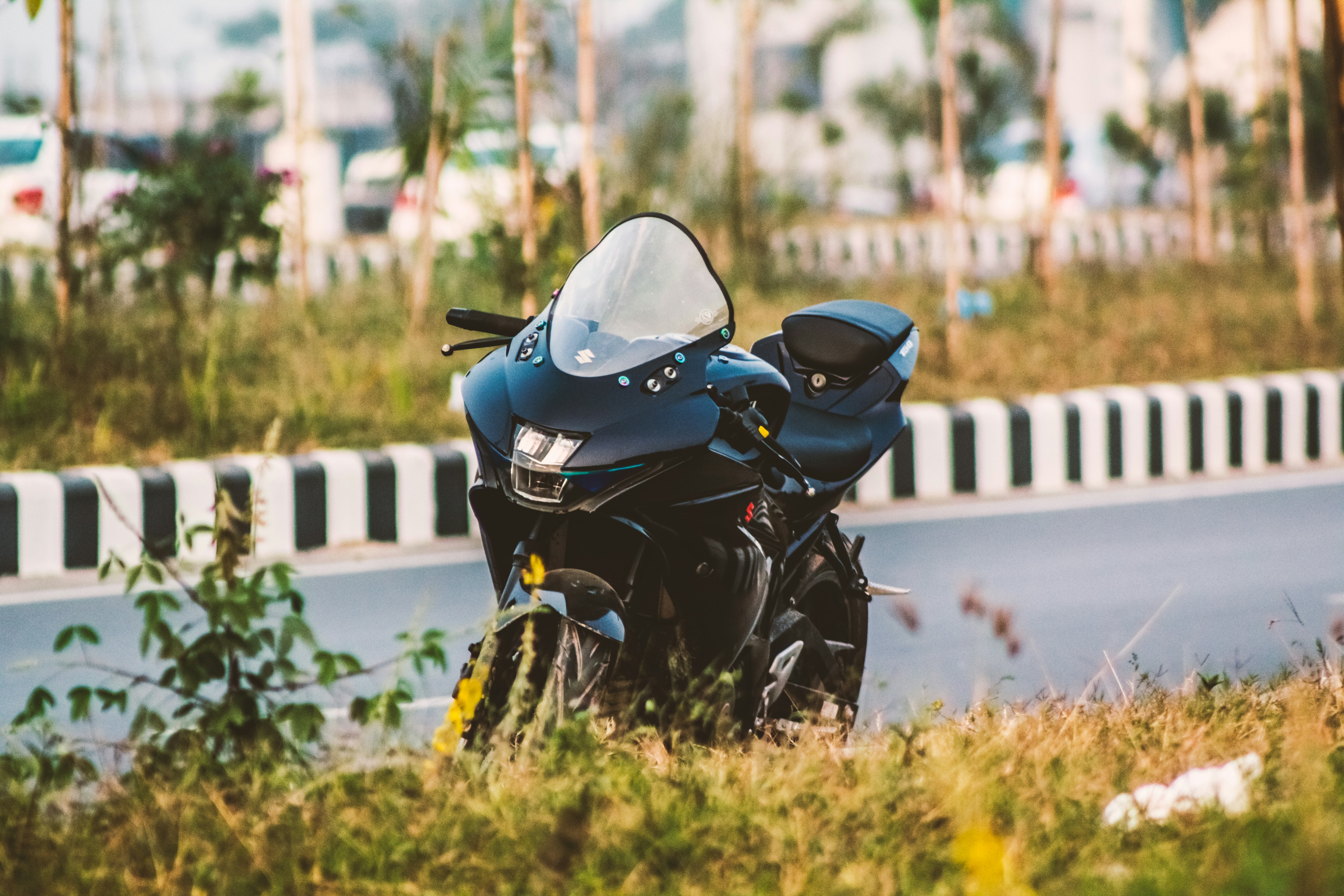 Grey Suzuki GSX-R sports bike parked at the side of a road