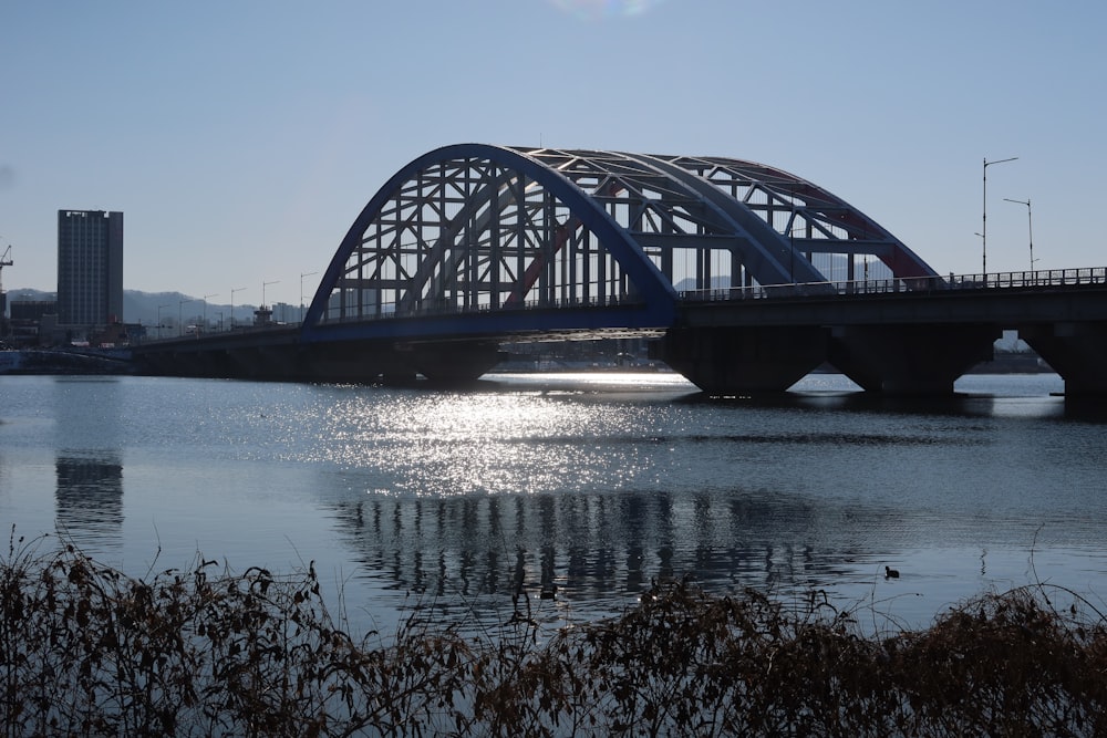 a bridge over a body of water with buildings in the background