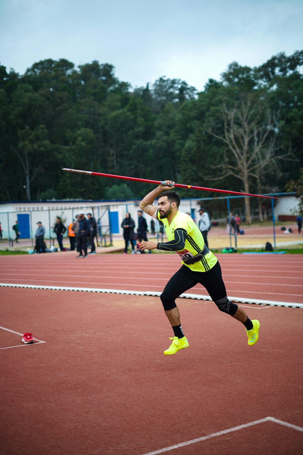 a man is running on a track with a stick