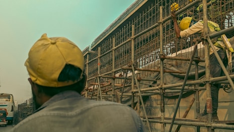 a man standing on a scaffold in front of a building