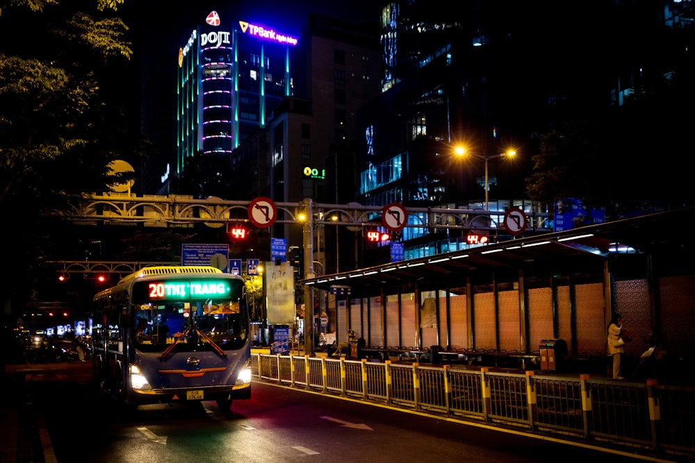 a bus driving down a city street at night