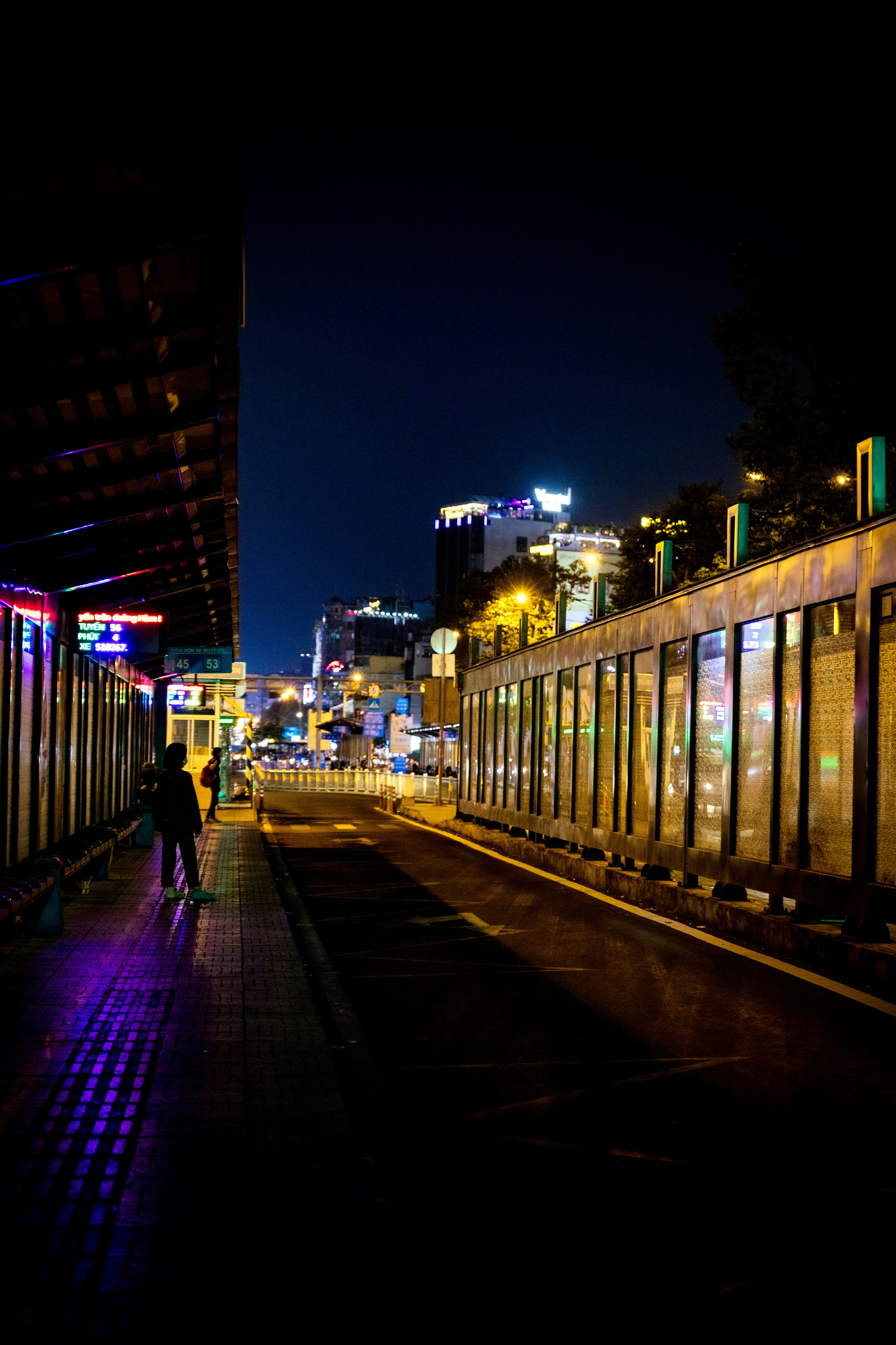 a person walking down a street at night